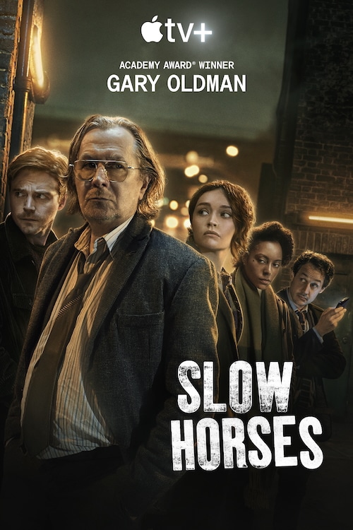 Promotional poster for the Apple TV+ series "Slow Horses" featuring Gary Oldman and the main cast standing in a dimly lit alley, conveying a gritty espionage atmosphere.