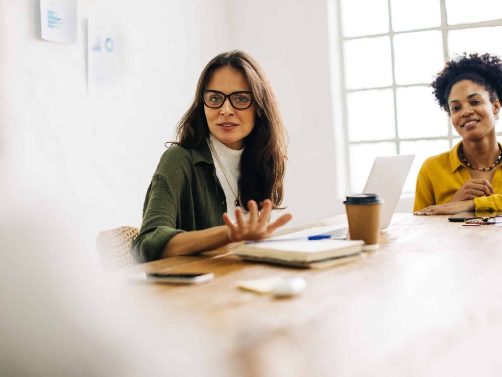 Woman with glasses speaking in a meeting in a conference room